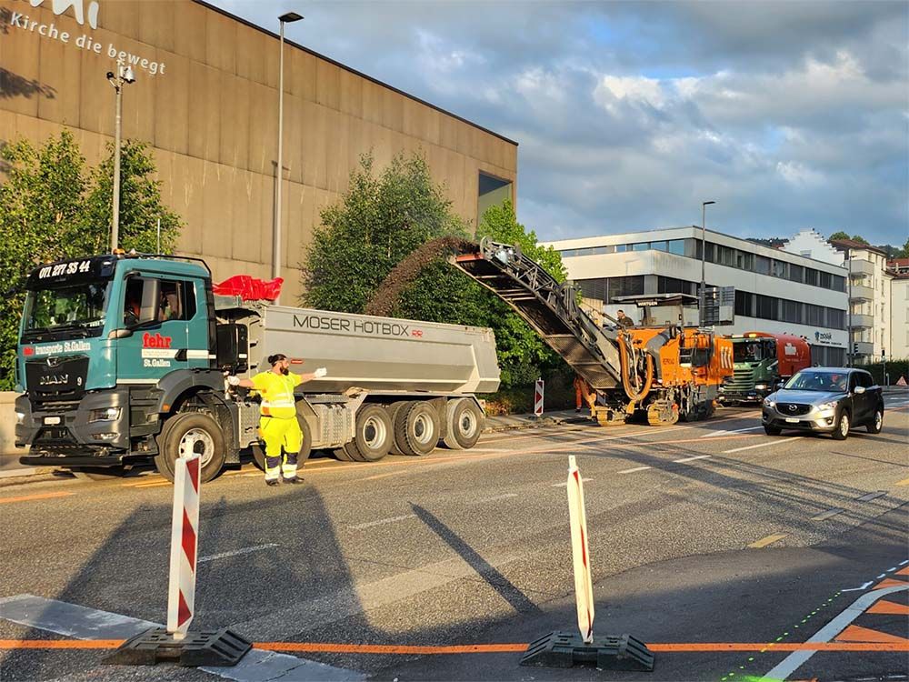 Verkehrsdienst weist den Verkehr an einer Baustelle ein